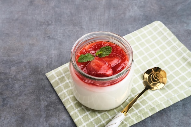 Sweet vanilla silky pudding dessert with strawberry sauce sliced fresh strawberries and mint leaf