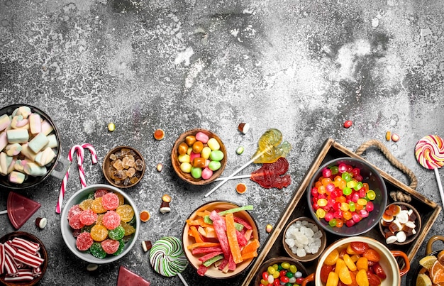 sweets candy, candied fruits with marshmallow and jelly on a wooden tray.