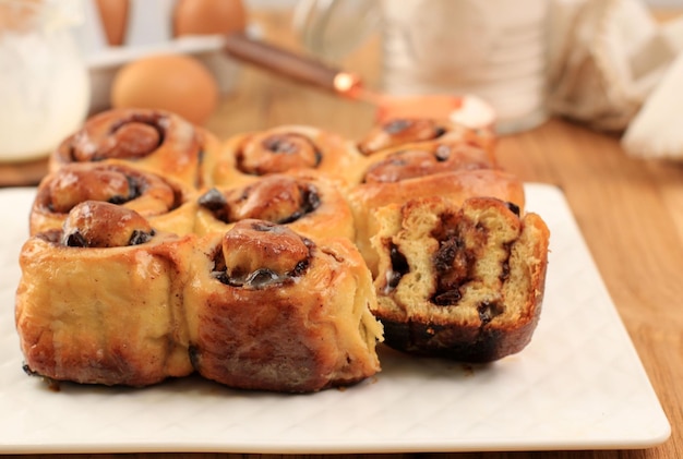 Sweets Cinnamon Roll with Cinnamon Powder, Half Cut. Serve on White Plate