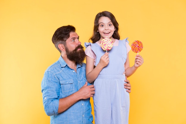 Sweets and treats concept Sugar diet Health care Sweet life How to please your child and avoid problems Sweet food Girl child and dad hold lollipops Sweet dessert Loving daddy for daughter