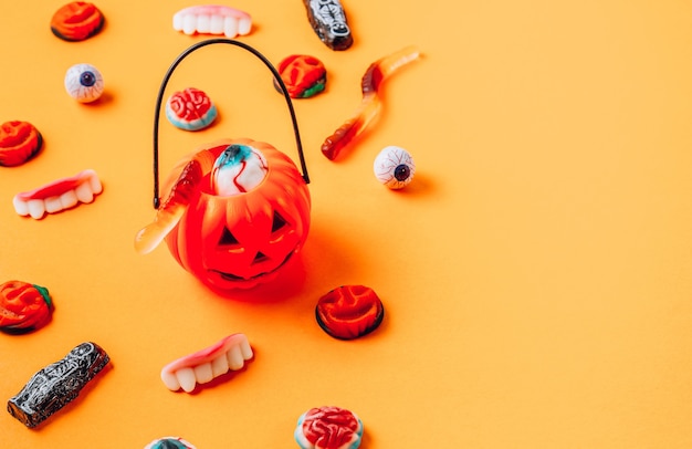 Sweets and treats for Halloween on orange background. Selective focus with copy space