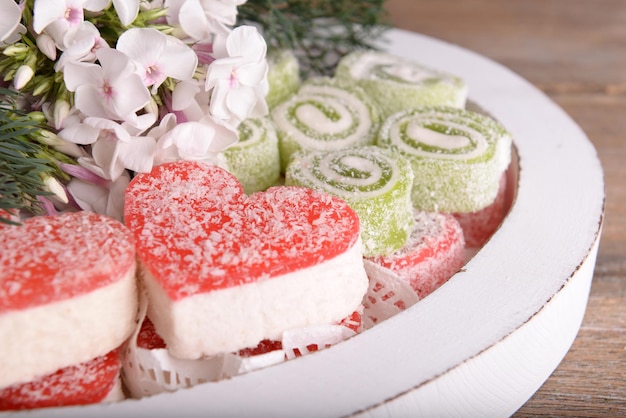 Sweets with flowers on wooden background