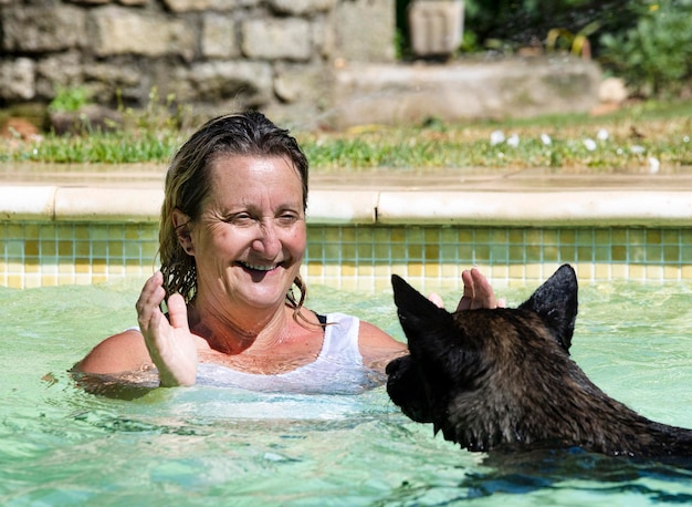 Swimming Dutch Shepherd and woman