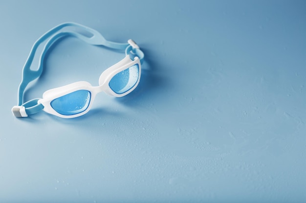 Swimming goggles in a white frame with on a blue