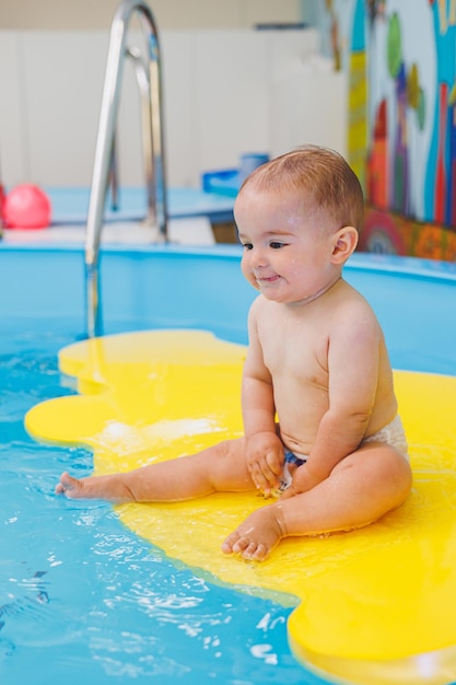 Swimming lessons for children A little boy is learning to swim in a baby pool Children's development First swimming lessons for children