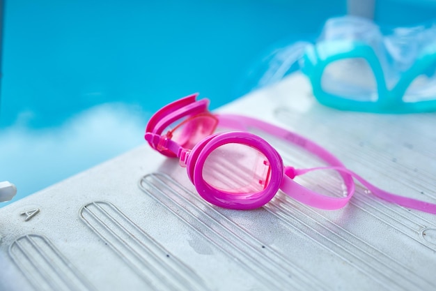 Swimming pink goggles blue diving mask is lying