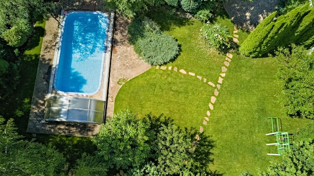 Swimming pool in beautiful garden aerial top view from above