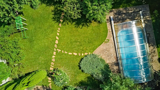 Swimming pool in beautiful garden aerial top view from above