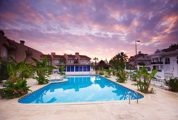 Swimming pool by the luxury resort hotel buildings