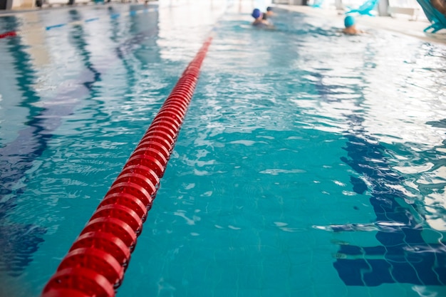 Swimming pool lanes in competition pool.red plastic rope lane on blue water indoor swimming pool sport competition