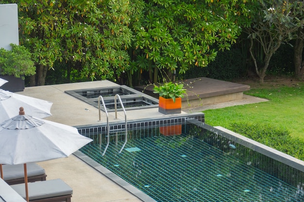 Swimming pool with metal stair with green nature  backgroun