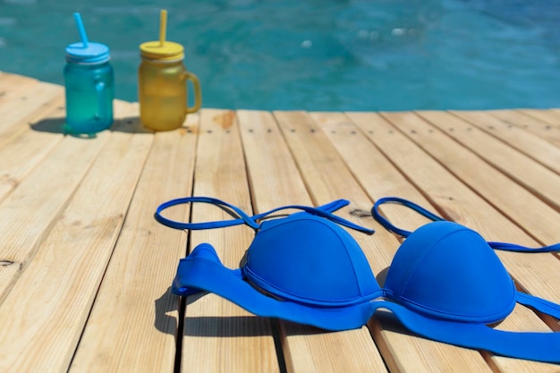 Swimsuit and two cocktails of yellow and blue standing by the pool Pool party outdoors