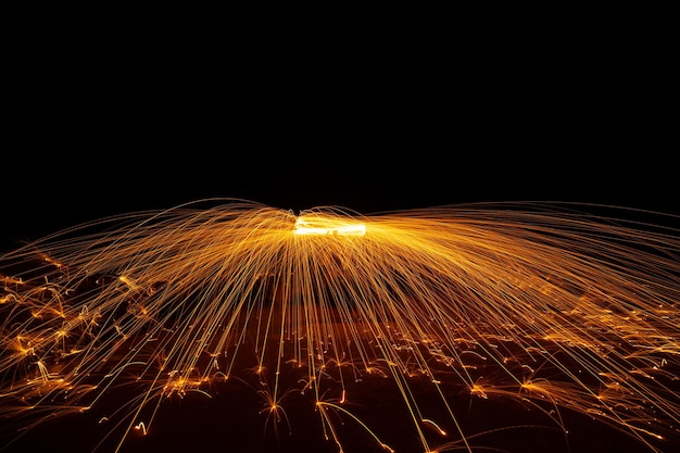 Swing fire Swirl steel wool light photography over the stone with reflex in the water Beautiful light in the sunrise or sunset time long exposure speed motion style