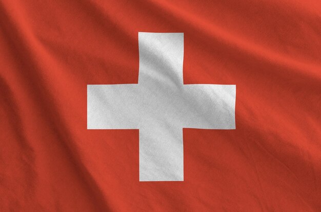 Photo switzerland flag depicted on folded wavy fabric of old cloth