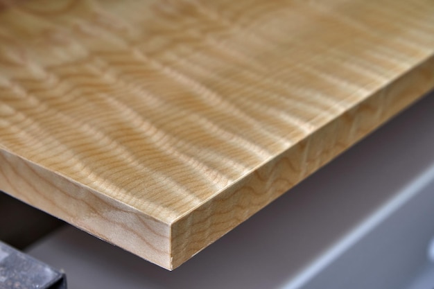 Sycamore maple cabinet door in workshop. High gloss cabinet door. Furniture manufacture. Closeup