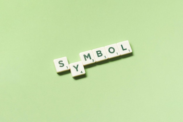 Symbol formed of scrabble blocks on green background