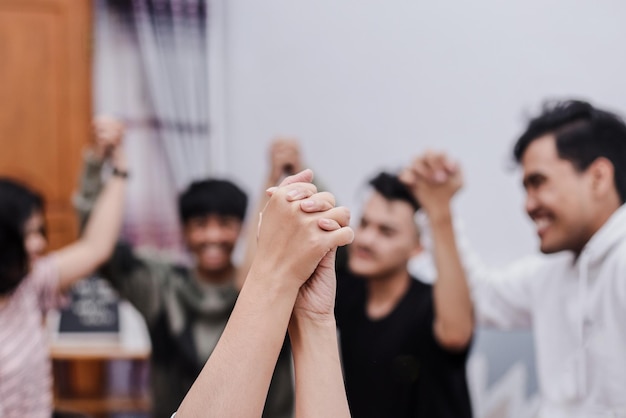 Symbolic picture showing that we are stronger together. Two people holding hand and raising in unity