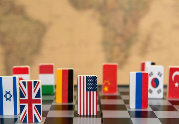 Symbols of countries on the chessboard against against the background the political map