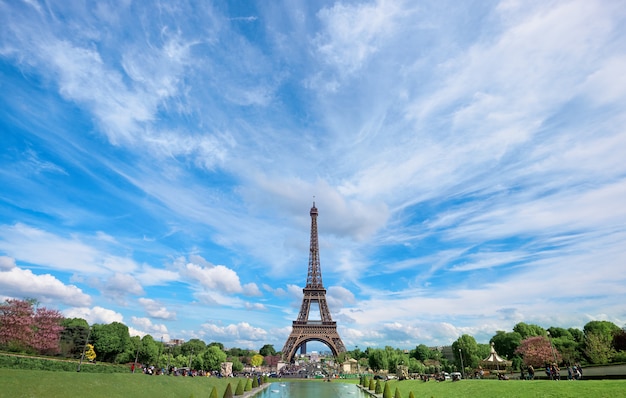 Symmetrical front panoramic view of Eiffel tower on a bright Summer day taken from fountains of Trocadero.