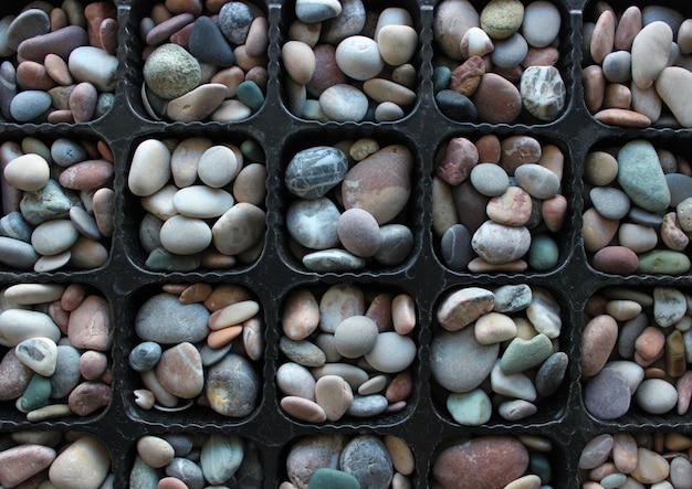 Symmetrical Pattern Of Plastic Tray With Same Cells Filled With Round River Rocks