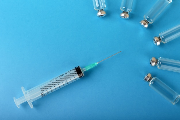 syringe and ampoules on blue background