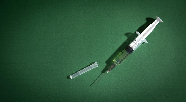 Syringe on the green background