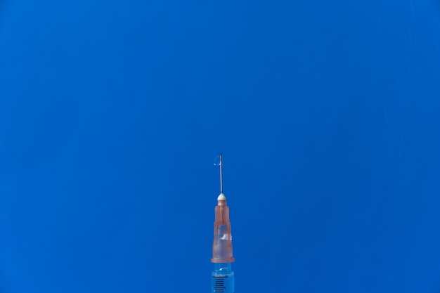 Photo syringe placed on a blue background. vaccination concept