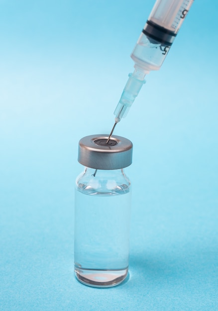 Syringe and vial on blue