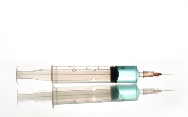 A syringe with a blue liquid, a photo on the topic of medicine and the prolongation of youth.