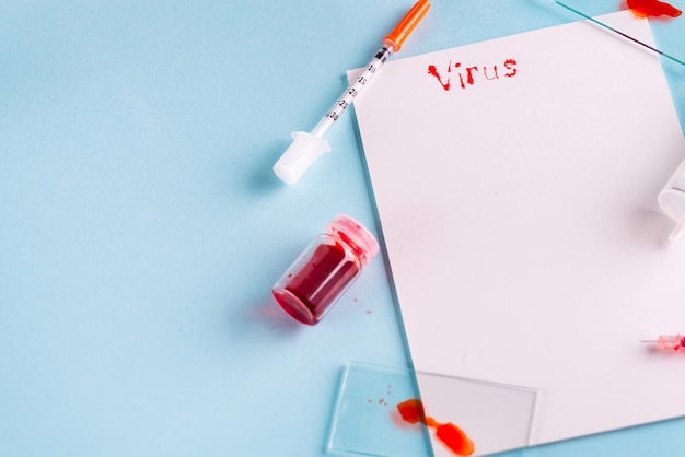 Syringes And Test Tube With Blood with white paper and the inscription Virus