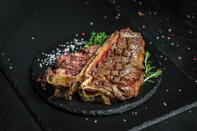 T-bone or aged wagyu porterhouse grilled beef steak with spices and herbs.