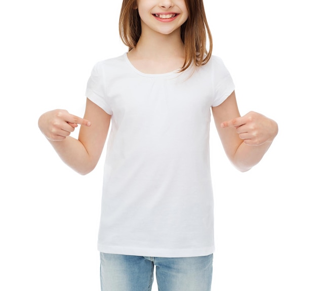 t-shirt design concept - smiling little girl in blank white t-shirt pointing at herself