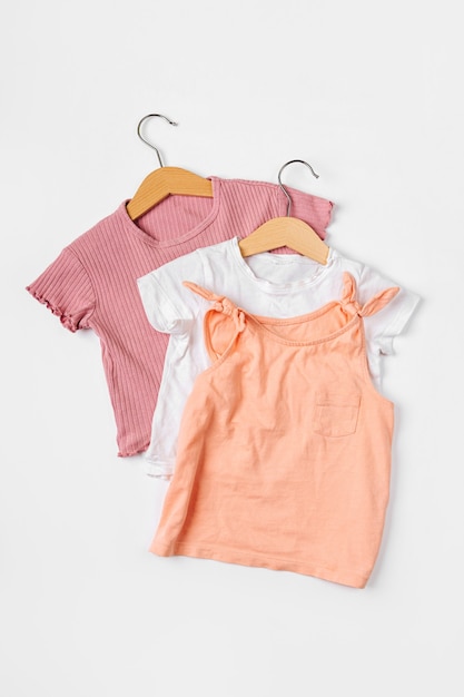 T-shirts on hanger. Set of baby clothes and accessories for spring, autumn or summer on  white background. Fashion kids outfit. Flat lay, top view