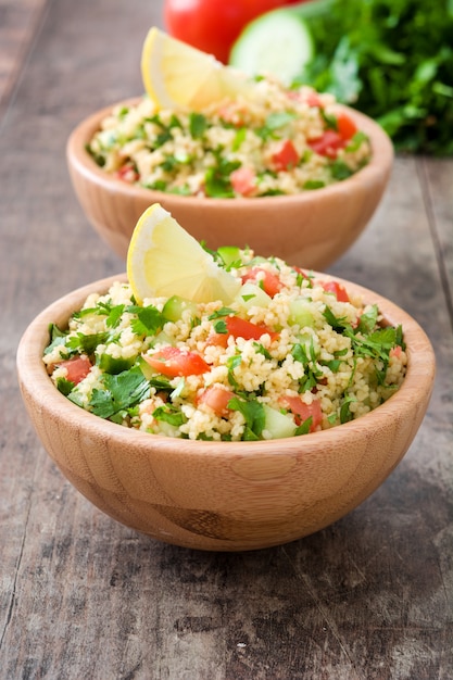 Tabbouleh salad with couscous in bowl on rustic table