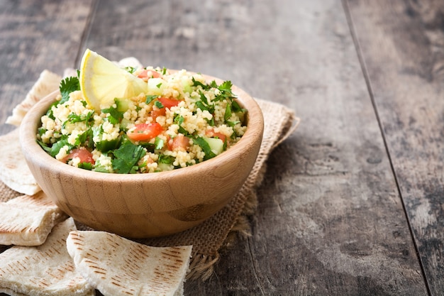 Tabbouleh salad with couscous on wooden table