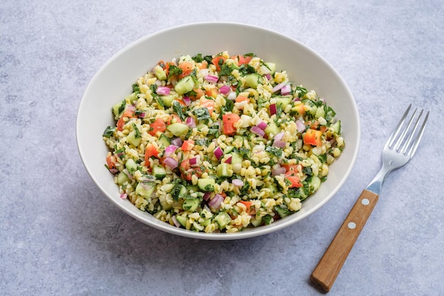 Tabbouleh salad with fresh herbs parsley, mint, bulgur, onion, diced cucumber, tomato. Healthy food