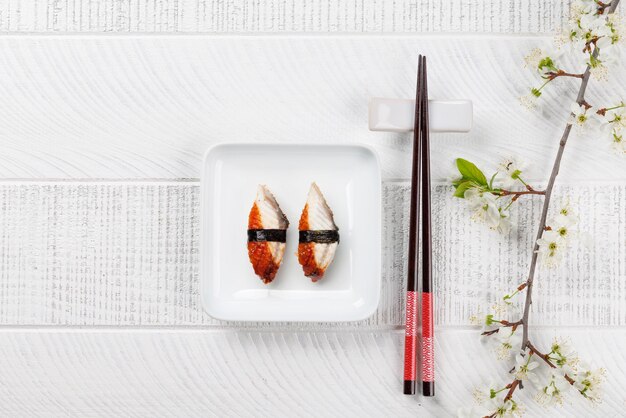 Photo table adorned with cherry blossom branch and chopsticks epitomizing japanese food culture