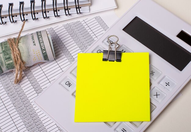 On the table are reports, notepads, cash, a white calculator and a yellow sticker with space to insert text or illustrations. Template. Business concept