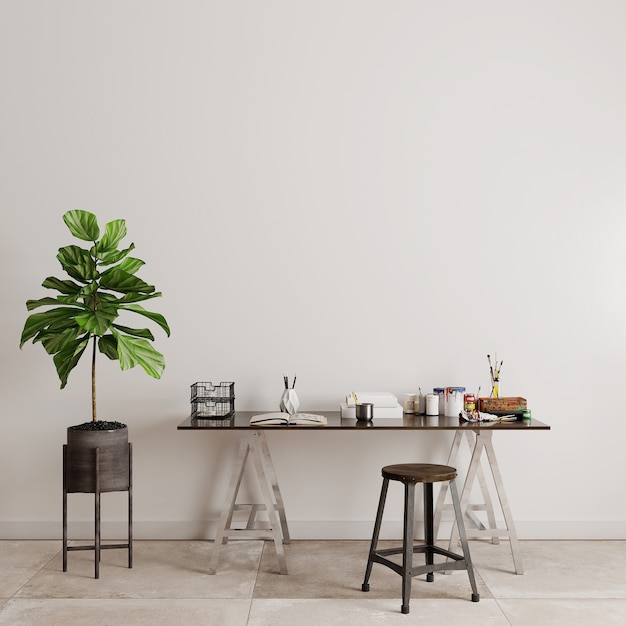 Table and chairs with green plants in front of the white wall