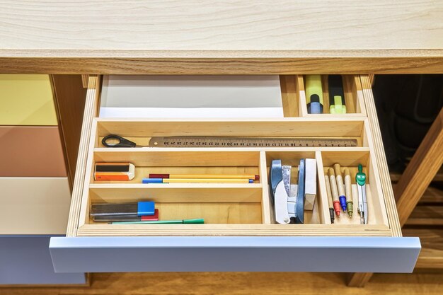 Table for children with multicolored facades of rollout drawers for stationery close view