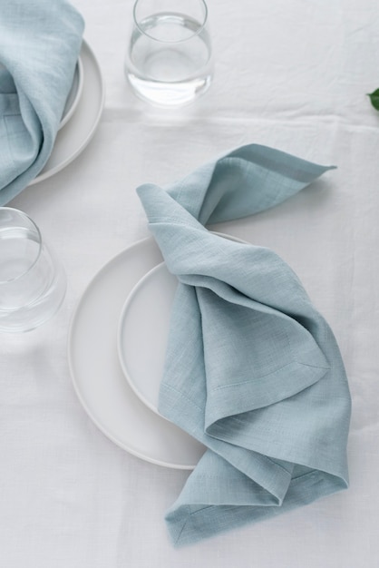 Table decor with white linen tablecloth and light blue napkins, selective focus image