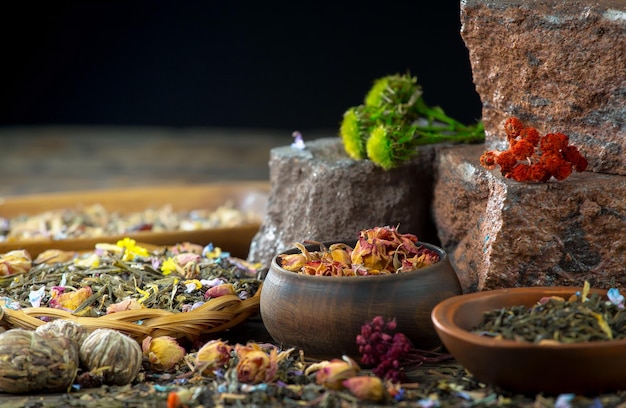 A table full of herbal teas and other herbs including a bowl of herbal tea.