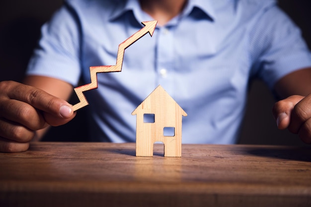 On the table is a model of wooden houses The arrow goes up