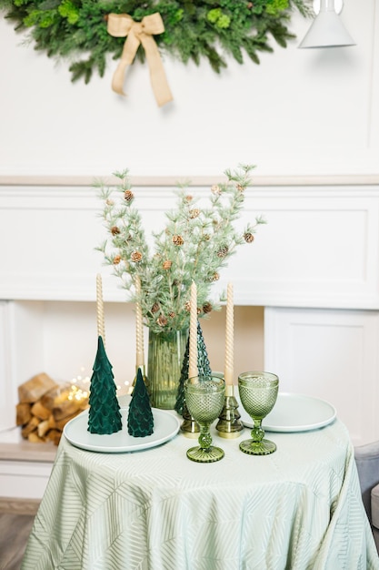 The table is set near the Christmas tree for a romantic New Year's dinner New Year's festive dinner