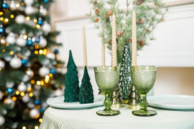 The table is set near the Christmas tree for a romantic New Year's dinner New Year's festive dinner