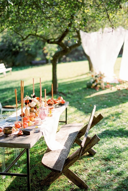 Table laden with dishes and candles stands in the garden