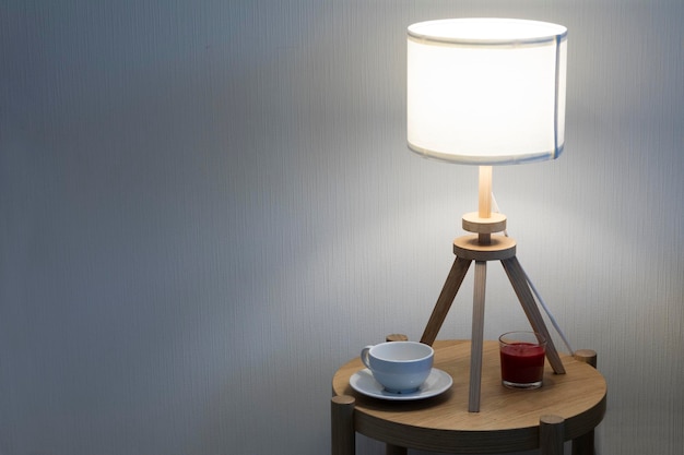 Table lamp next to mug and candle.