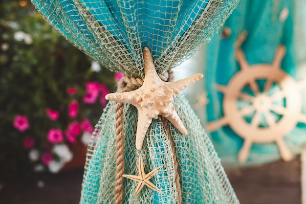 Table for painting on-site ceremony in a marine style. Decorated with nets, shells, anchor and helm