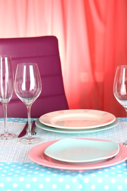 Table serving with colorful tableware on room background