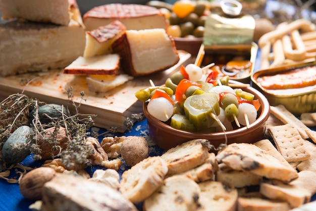 table set with an aperitif consisting of different foods cheeses and cans of pickles